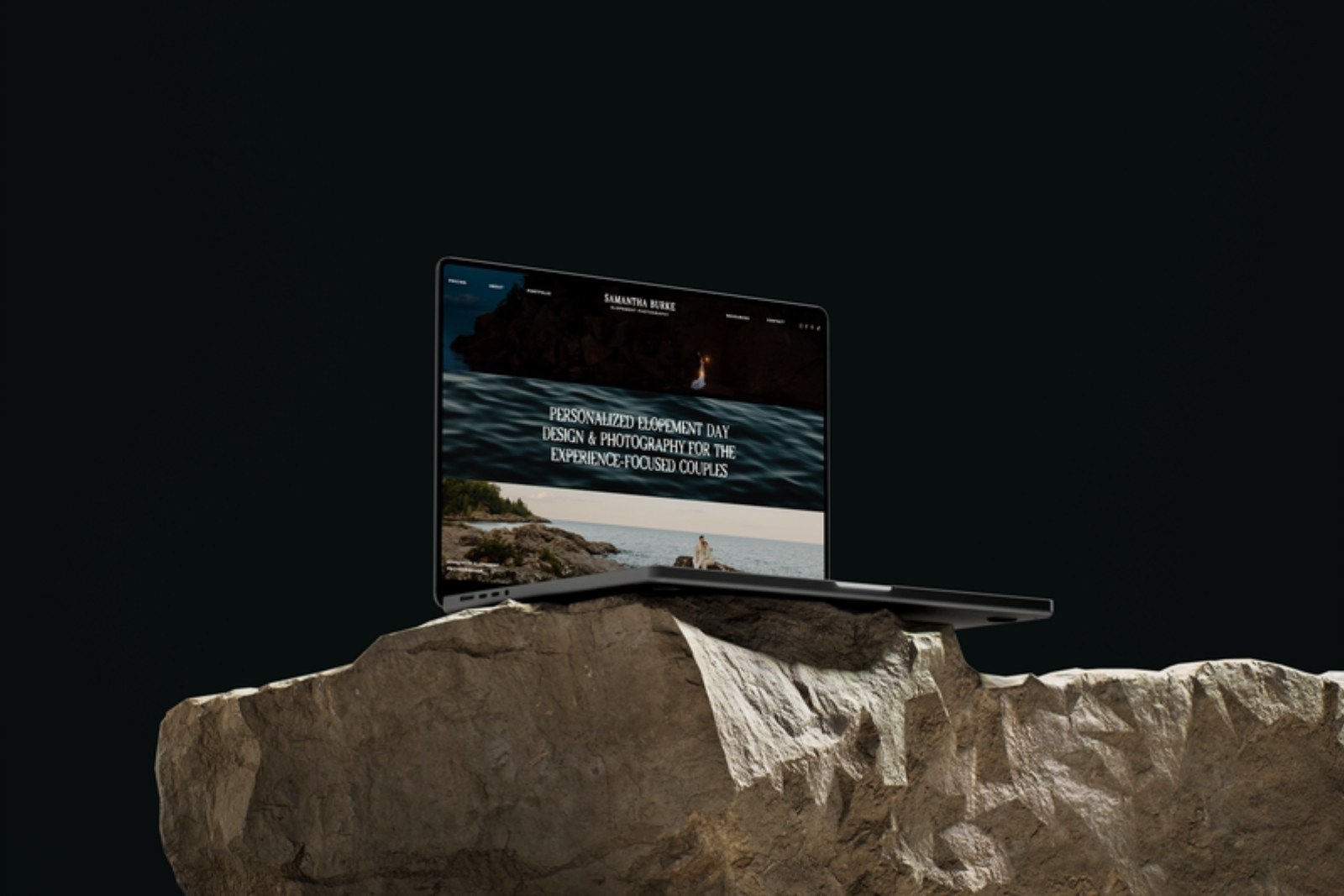 Laptop on a boulder displaying the Samantha Burke Photography homepage